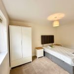 Modern bedroom with bed, wardrobe and window.