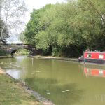 Canal with narrowboat and stone bridge