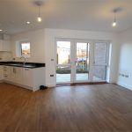 Modern open-plan kitchen with wooden flooring.
