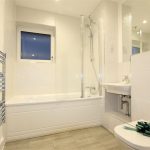 Modern bathroom with bath, shower, and towel rail.