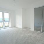 Empty room with carpet and large window.