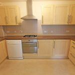 Modern kitchen with wooden cabinets and appliances.