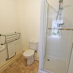 Modern bathroom with shower, sink, and toilet.