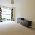 Empty room with large window and cabinets.
