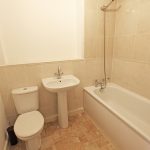 Modern bathroom with toilet, sink, and bathtub.