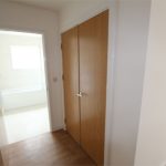 Hallway with wooden doors and bathroom entrance.