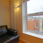 Cosy room with leather sofa and large window.