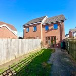 Back garden with brick house and wooden fence