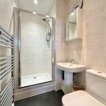 Modern bathroom with shower, sink, and toilet.