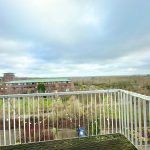 View from balcony overlooking buildings and greenery.