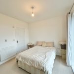 Minimalist bedroom with bed and white curtains.