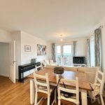 Modern living room with dining table and TV.
