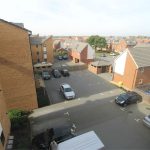 Aerial view of residential car park and houses.