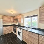 Modern kitchen with appliances and wood cabinets.