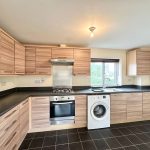 Modern kitchen with wooden cabinets and appliances.