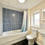 Modern bathroom with bathtub and window.