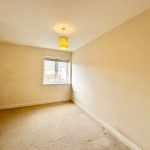 Empty room with beige walls and window.
