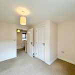 Empty neutral-coloured room with door and lamp