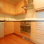 Modern kitchen with wooden cabinets and appliances.
