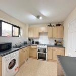 Modern kitchen with appliances and wooden cabinets.