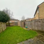 Suburban garden with fences and a patio area.