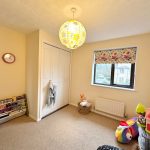 Children's room with toys and bright window shade.