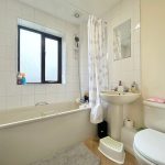 Modern bathroom with bathtub, sink and toilet.