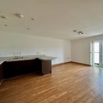 Modern open-plan kitchen and living area with balcony.