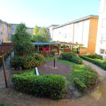 Sunny residential courtyard with green gardens.