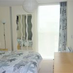 Modern bedroom with patterned bedding and abstract mirrors.