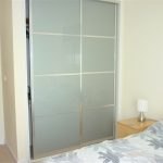 Bedroom with sliding wardrobe and bedside lamp