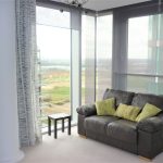 Modern lounge with leather sofa and city view.