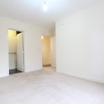 Empty room with beige carpet and doors open.