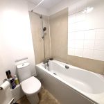 Modern bathroom with bathtub and toiletries.