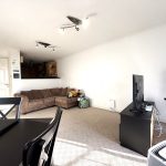 Bright living room with sofa, table, and TV.