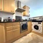 Modern kitchen with wooden cabinets and appliances.