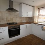 Modern kitchen with wooden countertops and gas hob.