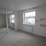 Empty room with mirrored wardrobe and shelves.