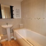 Modern bathroom with bathtub, sink, and toilet