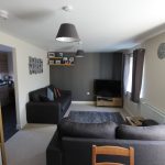 Modern living room with grey sofas and TV.