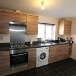 Modern kitchen with wooden cabinets and appliances.