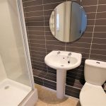 Modern bathroom with shower, sink, and toilet
