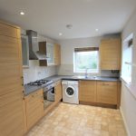 Modern kitchen with wooden cabinets and appliances.
