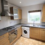 Modern kitchen with wooden cabinets and appliances.