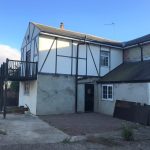 Two-storey house with timber frame and balcony.