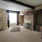 Cosy lounge with brick fireplace and exposed beams.