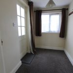 Empty hallway with window and coat hooks.