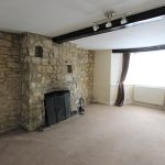 Living room with stone fireplace and large window