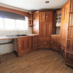 Rustic wooden kitchen with ample cabinetry and sink.