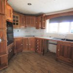 Rustic wooden kitchen with corner cabinets.